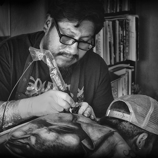 Gunnar tattooing a client's back